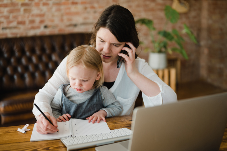 Mother working while holding a child